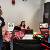 Three students at booth posing for photo